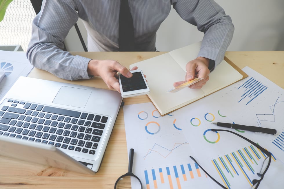 Man Holding Credit Card and Using Laptop in the Office