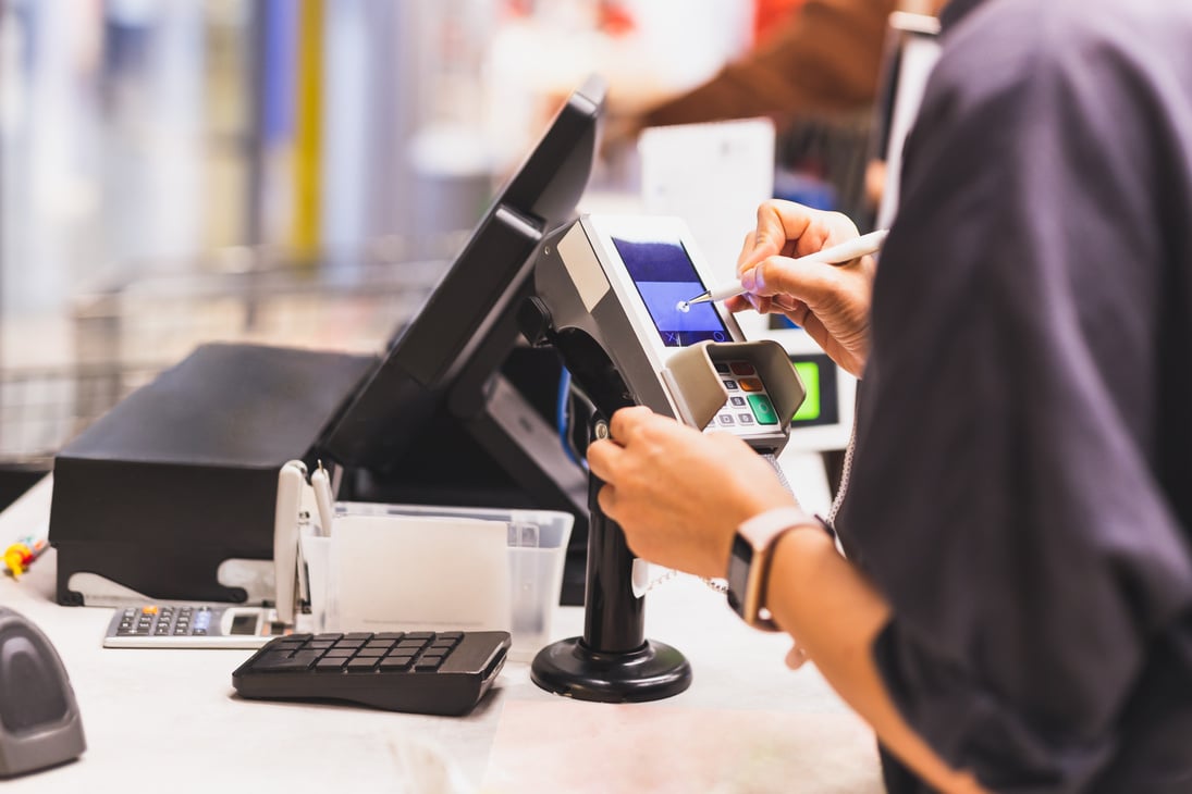 Consumer's women signing on a touch screen of credit card sale t